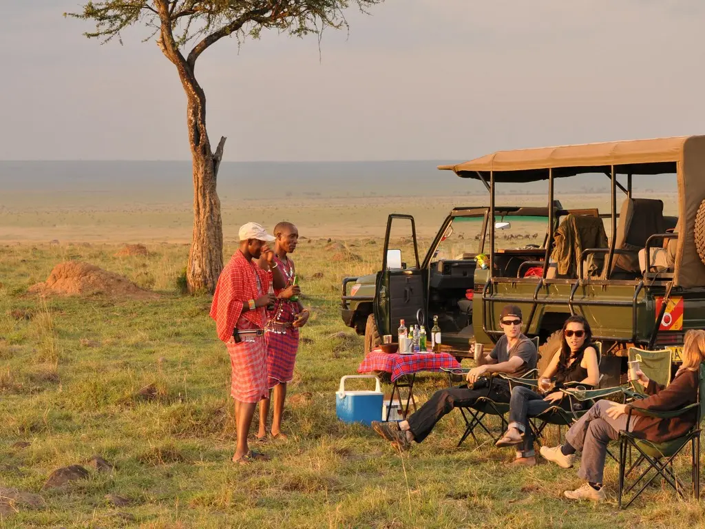 Kenya Safari Holiday - Discover big and small creatures during your Kenya walking tour. Guests enjoying a picnic lunch in Masai Mara.