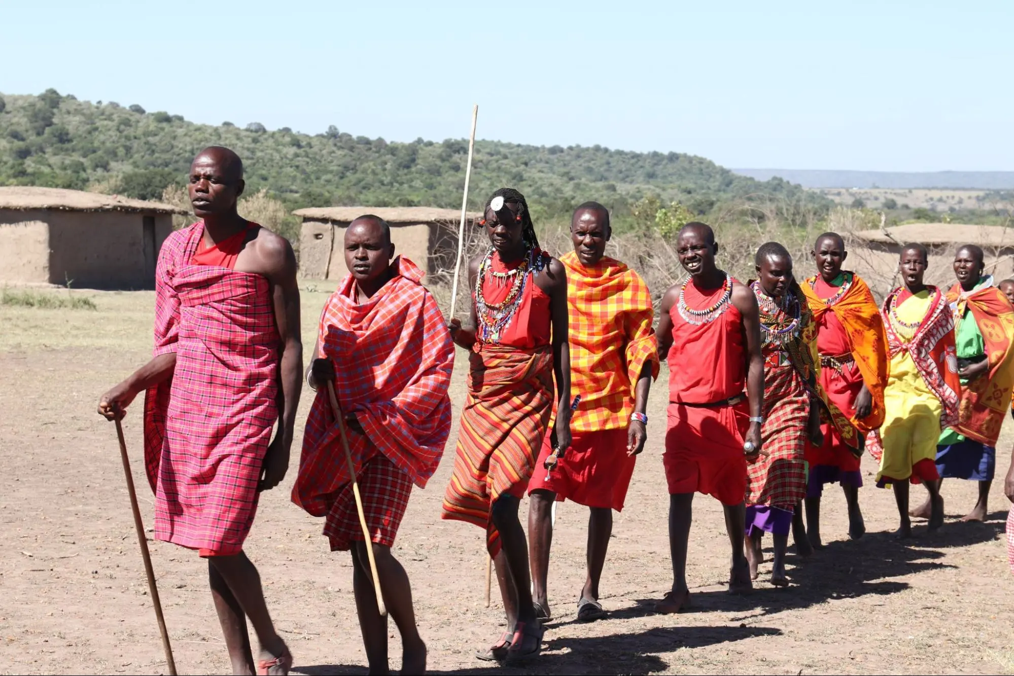 A multicultural gathering of individuals taking a leisurely walk in the local community of Serengeti, Tanzania.